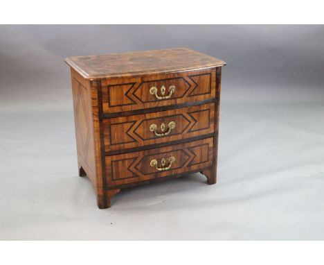 A French Regence olivewood and rosewood bowfront commode, c.1725, with parquetry decoration and three long drawers, on bracke