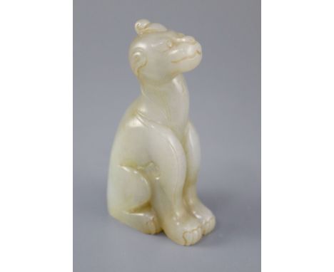 A Chinese pale celadon and russet jade figure of a mythical beast, the figure seated with a single horn and a scrolling tail 