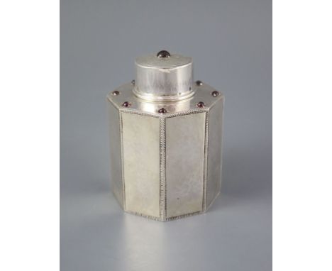 A George V Liberty &amp; Co silver and nine stone cabochon garnet set octagonal tea caddy and cover, with planished and engra