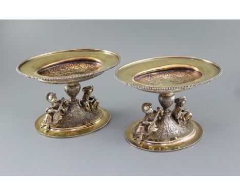 A handsome pair of Victorian parcel gilt silver oval comports by Hunt &amp; Roskell (lacking glass bowls), each with beaded r