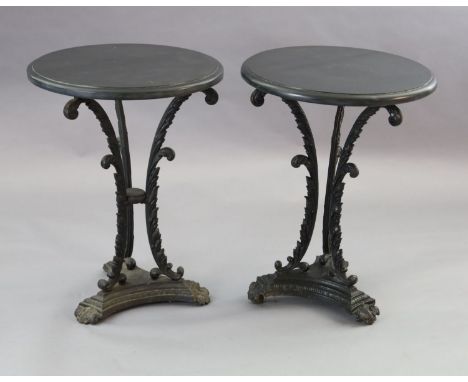 A pair of early Victorian cast iron occasional tables, with later circular black granite tops, foliate scroll underframes and