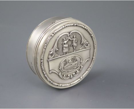 A George V silver circular box and hinged cover, embossed with a ship and dancing figures above, with engraved inscription, '