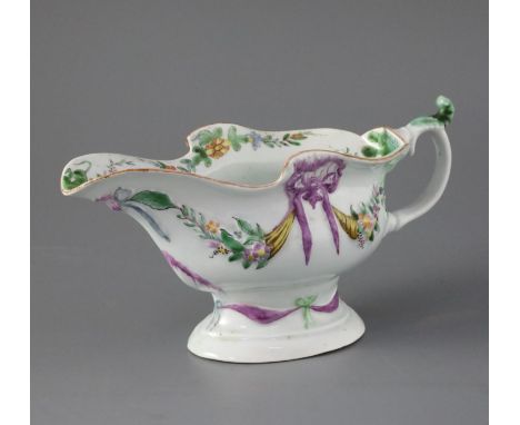 An early Worcester high-footed sauceboat, circa 1752-3, of oval shape, the body embossed with cornucopias of flowers and frui