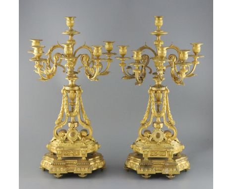 A pair of late 19th century French ormolu six light candelabra, with foliate scroll vineous branches, swagged stems and serpe