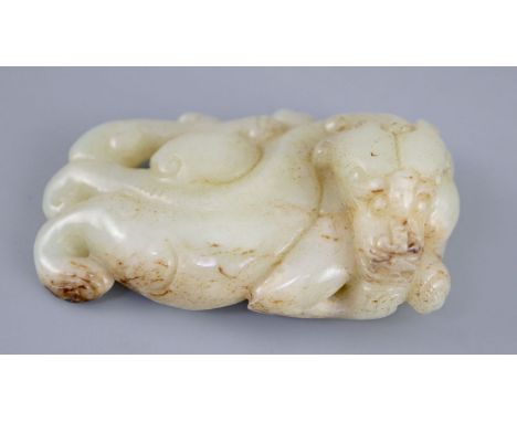 A Chinese pale celadon jade figure of a chilong, the figure with scrolling tail, the stone with creamy inclusions and russet 