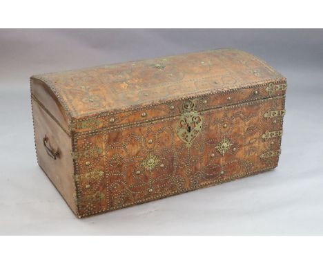 A 17th century Russian leather travelling trunk, the domed top with brass studded decoration forming floral motifs, similarly