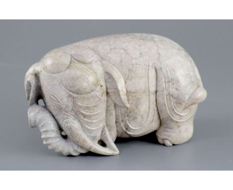 A Chinese burnt jade figure of an elephant, standing turning its head to dexter, 15.5cm longCONDITION: The stone has lots of 