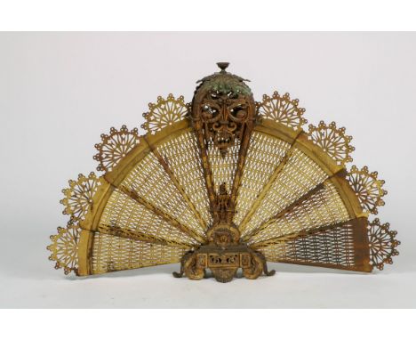 A fan shaped or peacock firescreen, copper, late 19th century. Meas. H: 61 cm. Estimate: € 40 - € 60.
