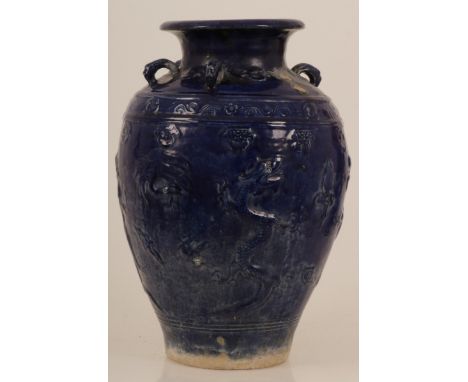 An earthenware blue glazed storage jar with dragon decoration. China, 20th century. Dimensions: 63 x 37 cm. One handle is mis