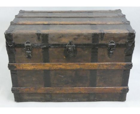 A Victorian travelling trunk, the canvas panels overlaid with wood and metal bands, raised on brass rollers, 92 x 56 x 64 cm.