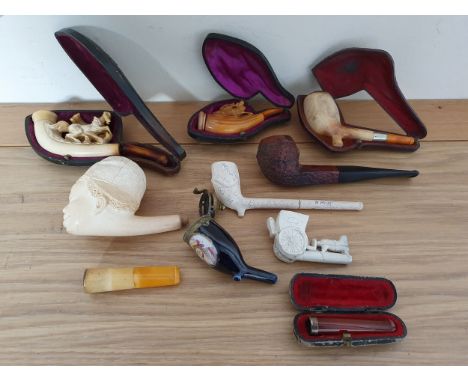 A meerschaum pipe in the form of a black youth with cap, a rearing horse pipe and other pipes.