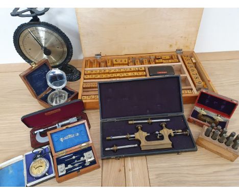A wooden printers block alphabet and number set, cased, various instruments and a Salter Family Scales.