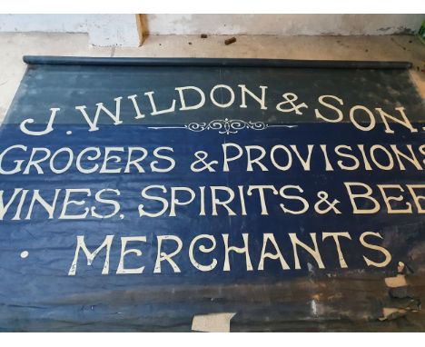 An Edwardian blue canvas roller shop banner, white painted "J. Wildon &amp; Sons.....", 220 x 355 cm together with a price ca