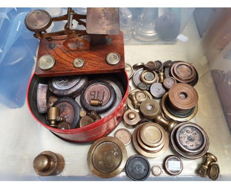 An Edwardian oak and brass set of scales, with weights, and a quantity of brass, copper and steel weights