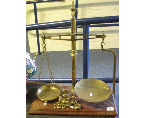 Large set of brass pillar scales with weights, on mahogany base.(B.P. 24% incl. VAT)