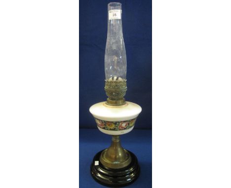 Early 20th Century brass double burner oil lamp with ceramic reservoir on brass pedestal with ceramic base and glass chimney.