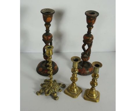 A pair of Kashmiri carved wood and painted lacquered candlesticks, with multi twist columns; together with a pair of brass ca