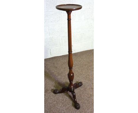 A George III style mahogany torchere, 20th century reproduction, with turned and fluted pillar set on a tripod base with paw 