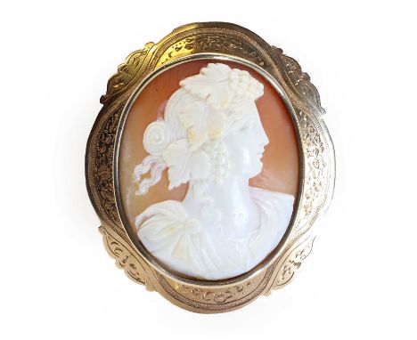 A gold mounted Victorian shell cameo brooch,depicting Bacchus, bezel set to a hand-engraved scrolling frame. Brooch fittings 