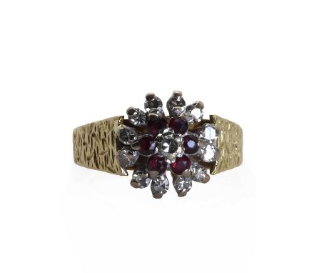 An 18ct gold ruby and diamond floral cluster ring, an eight cut diamond bead set to the centre, to a surround of circular cut