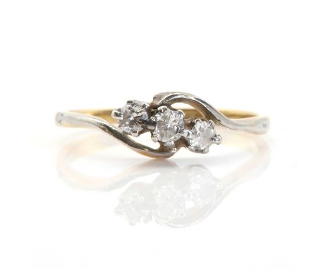 A gold crossover design three stone diamond ring, three graduated round brilliant cut diamonds claw set to white collets, to 