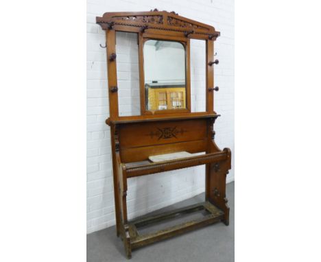 Late 19th century oak hall stand with a pierced top rail above a central mirror with a surround of eight coat hooks, above an
