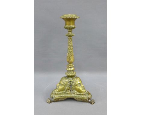 Regency cast brass taper stick with classical figure heads, triform base and paw feet, 24cm 