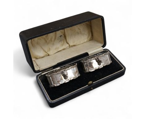 A cased pair of George V silver oval napkin rings, each with a fox head surmount, Adie Brothers, Birmingham, 1928, 72mm.