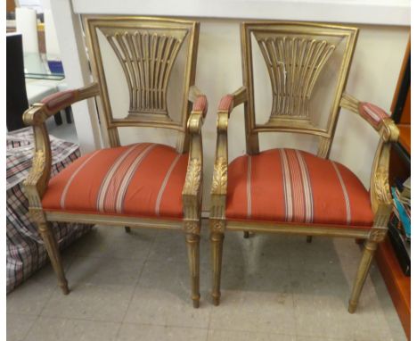 A pair of modern French 19thC style gold and cream wash painted open arm bedroom chairs with a fabric covered seat, raised on