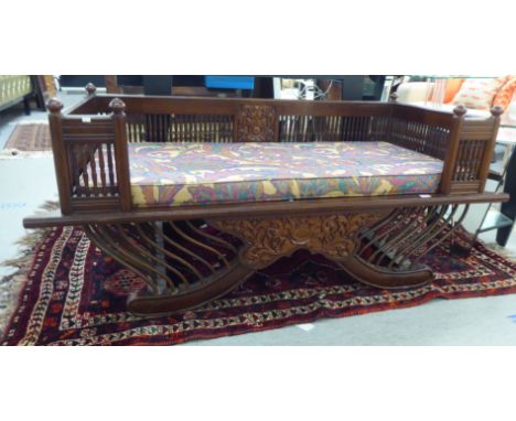 A modern Asian, mahogany, traditionally styled and carved, galleried daybed/bench seat with a floral decorated squab cushion&