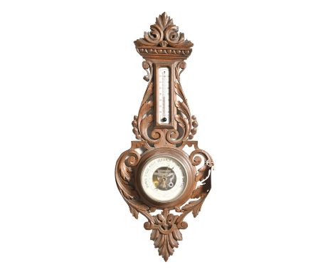 A carved and pierced walnut aneroid barometer, c1900, with alcohol thermometer and enamel scale, 68cm h In apparently good co