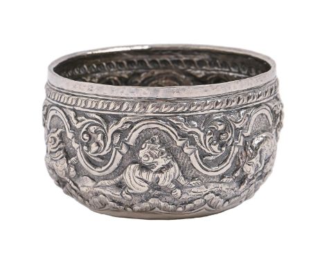 A Burmese silver repousse bowl, early 20th c, worked in high relief with elephant, tiger and other animas, 75mm diam, circula