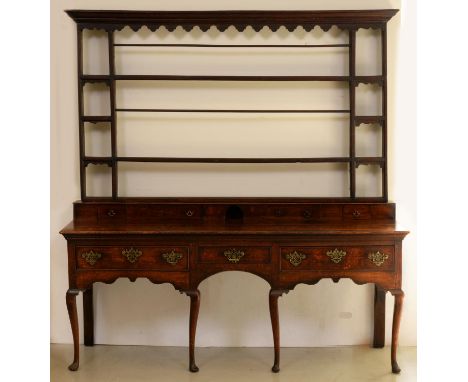 A George III oak dresser, the low upstand fitted with spice drawers beneath associated rack, the base with three drawers, sha