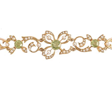A peridot and split pearl bracelet, early 20th c,&nbsp;&nbsp;in gold with flower shaped and oval openwork links, fully articu