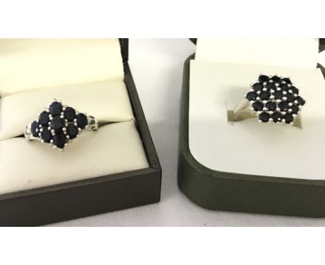 2 silver sapphire set dress rings. One traditional cluster and one diamond shaped cluster. Both size K.