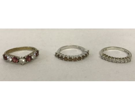 3 silver stone set eternity style dress rings. Wishbone style set with garnets and clear stone, half eternity set with yellow