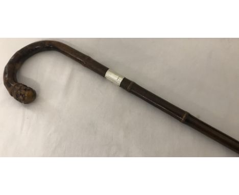 A bamboo style Walking stick with carved detail to handle and silver collar to neck. Hallmarked London 1918 