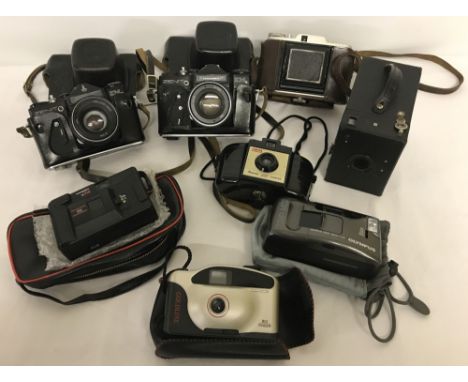 A box of assorted vintage cameras to include Box Brownie, a Bakelite Kodak Brownie 127 and 2 cased Zenit cameras. 