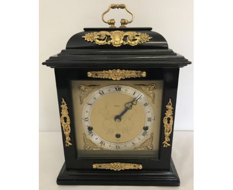 A reproduction wooden cased Elliott of London mantle clock with brass detail. 8-day lever Westminster and Whittington chime. 
