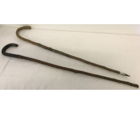 2 vintage walking sticks. A Swiss walking stick with 6 metal plaques together with one other.  