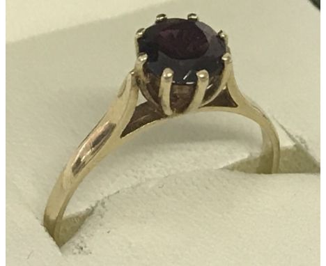 A 9ct gold high set garnet solitaire dress/engagement ring.  Ring O 1/2.