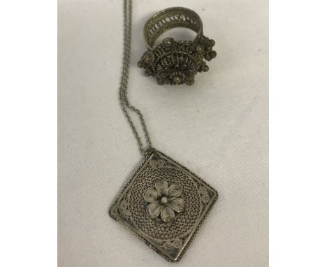 A vintage filigree work pendant on a chain. Together with a white metal ethnic style filigree ring. Ring size M.