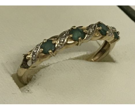 A 9ct gold emerald and diamond half eternity ring. Hugs and kisses design. One emerald missing. Ring size P 1/2.