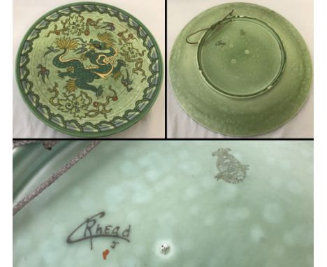 Charlotte Rhead green ceramic charger with an oriental dragon design.  Approx. 44cm diameter.