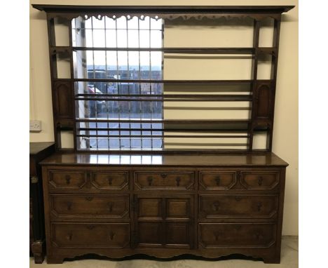 A large Georgian Oak dresser with plate rack. With 7 drawers and a single cupboard to base, complete with key. Plate rack top