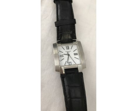A men's Tissot wrist watch. Black leather strap. With Roman numeral hour markers, seconds hand and date function. 