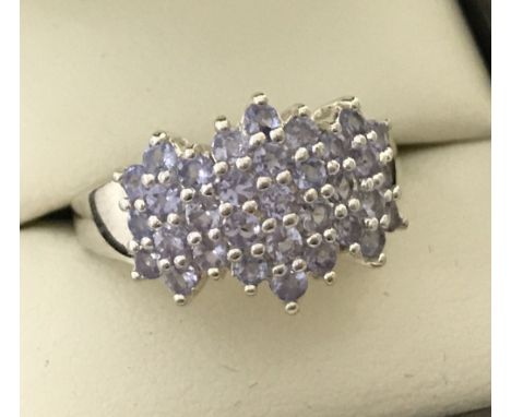 A ladies silver cluster style dress ring set with 31 small pale lilac stones.  Size O.