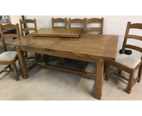 A large, heavy solid oak draw leaf rustic dining table with separate leaf. Together with 6 solid oak ladder back dining chair