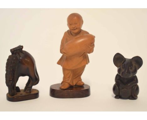 Carved Oriental figure of a boy together with two further wooden carvings, model of a gazelle and a wooden netsuke modelled a