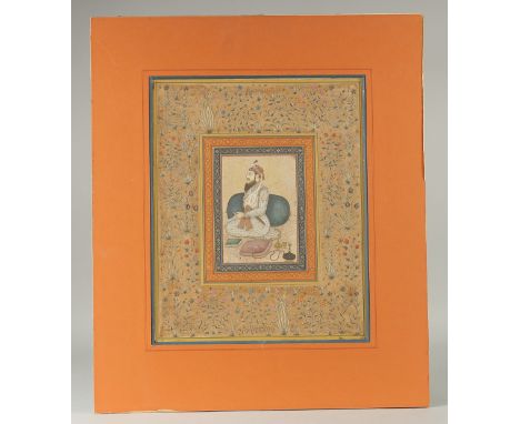 A LARGE INDIAN MINIATURE PAINTING, depicting a seated figure, a huqqa pipe beside him, with fine gilded foliate borders emana